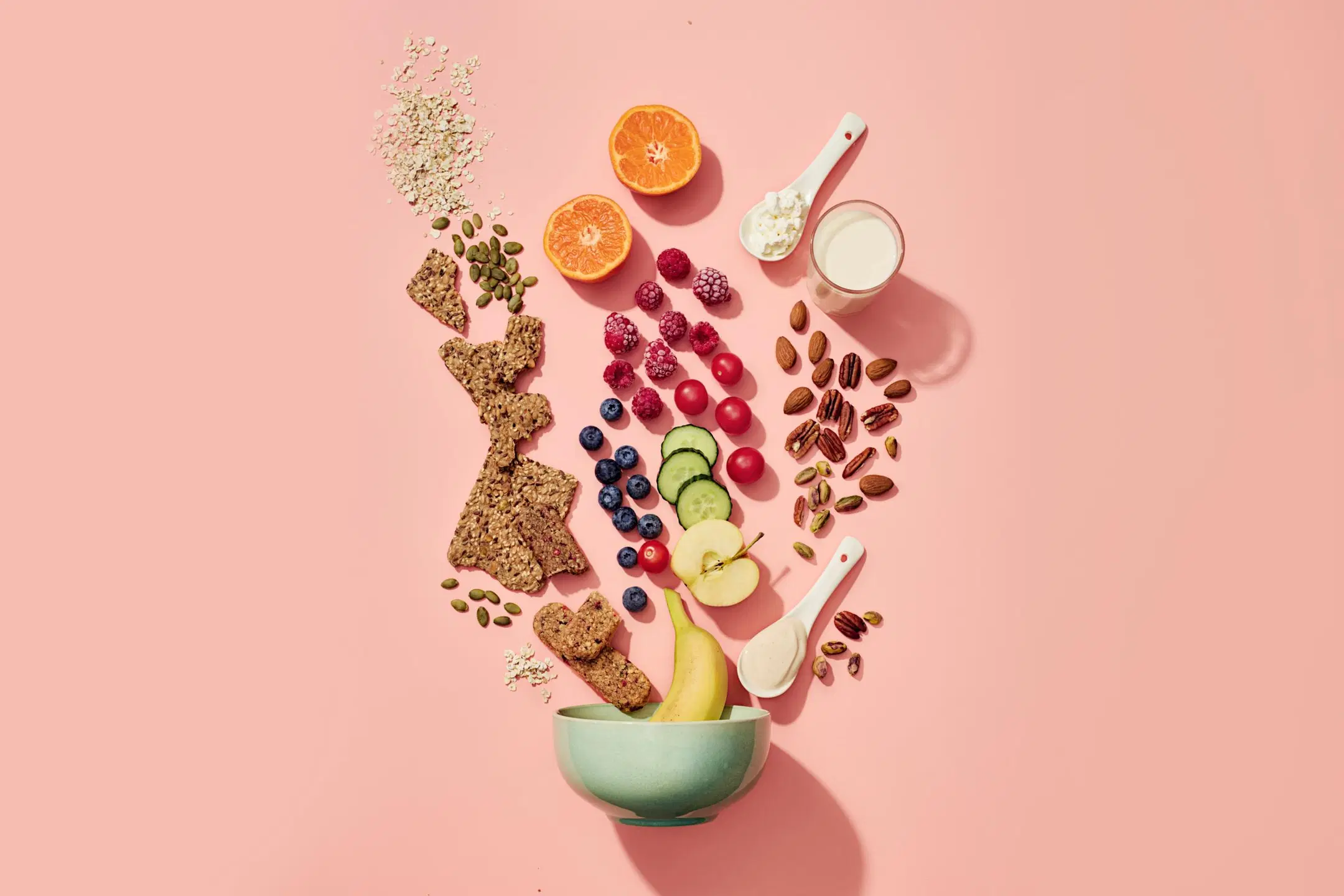 Välipalakulhosta tulee esiin hedelmiä, marjoja, pähkinöitä ja siemennäkkileipää.