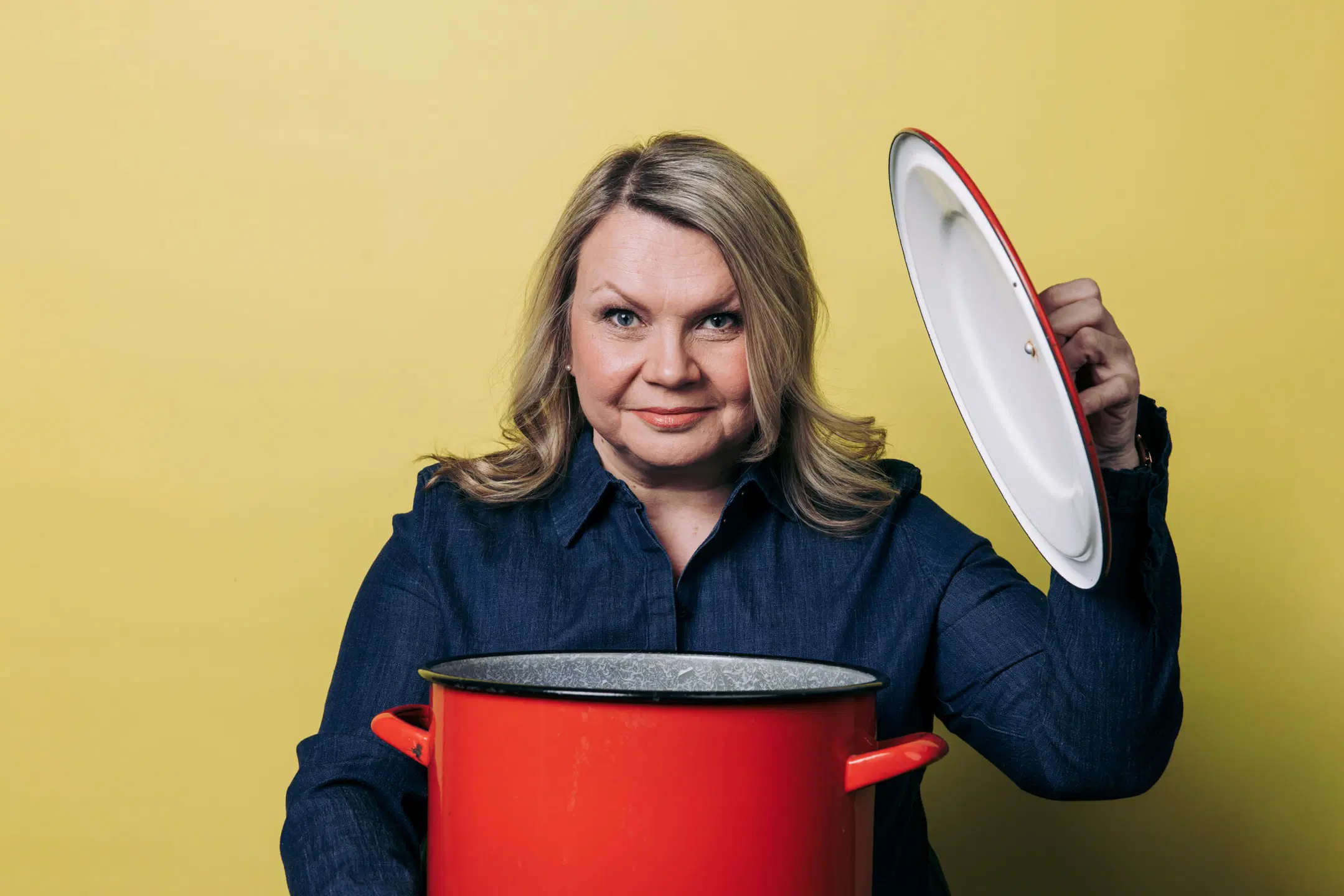 Ruokatoimittaja pitelee kattilaa kädessään