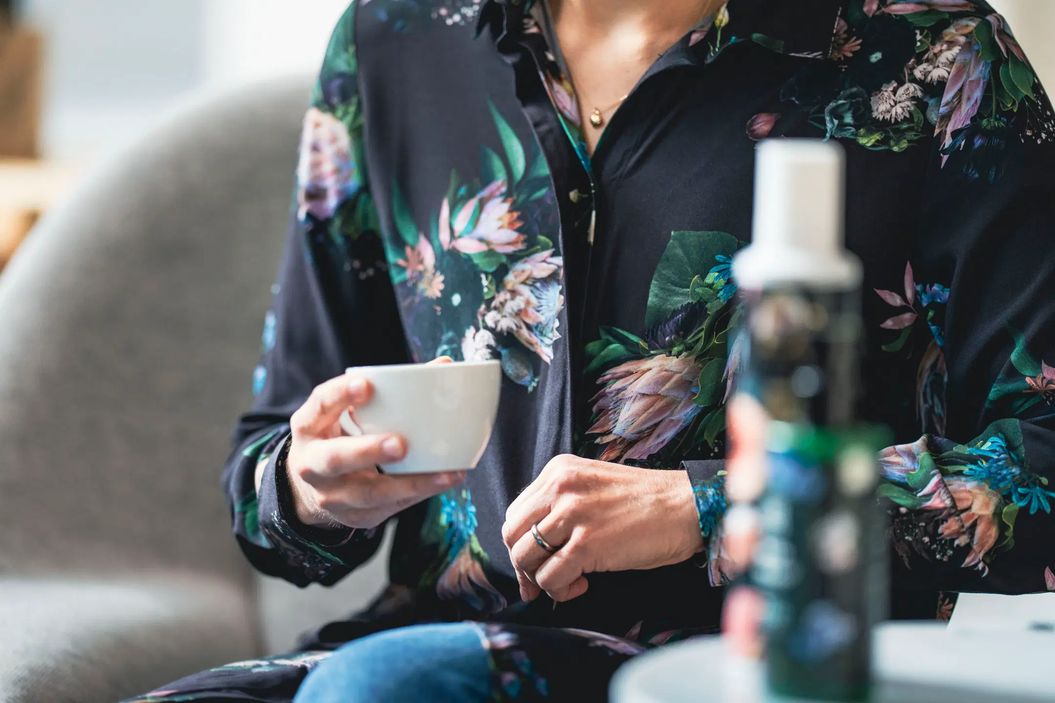 Nainen juo kahvia Uana-mekkisessä vaatteessa