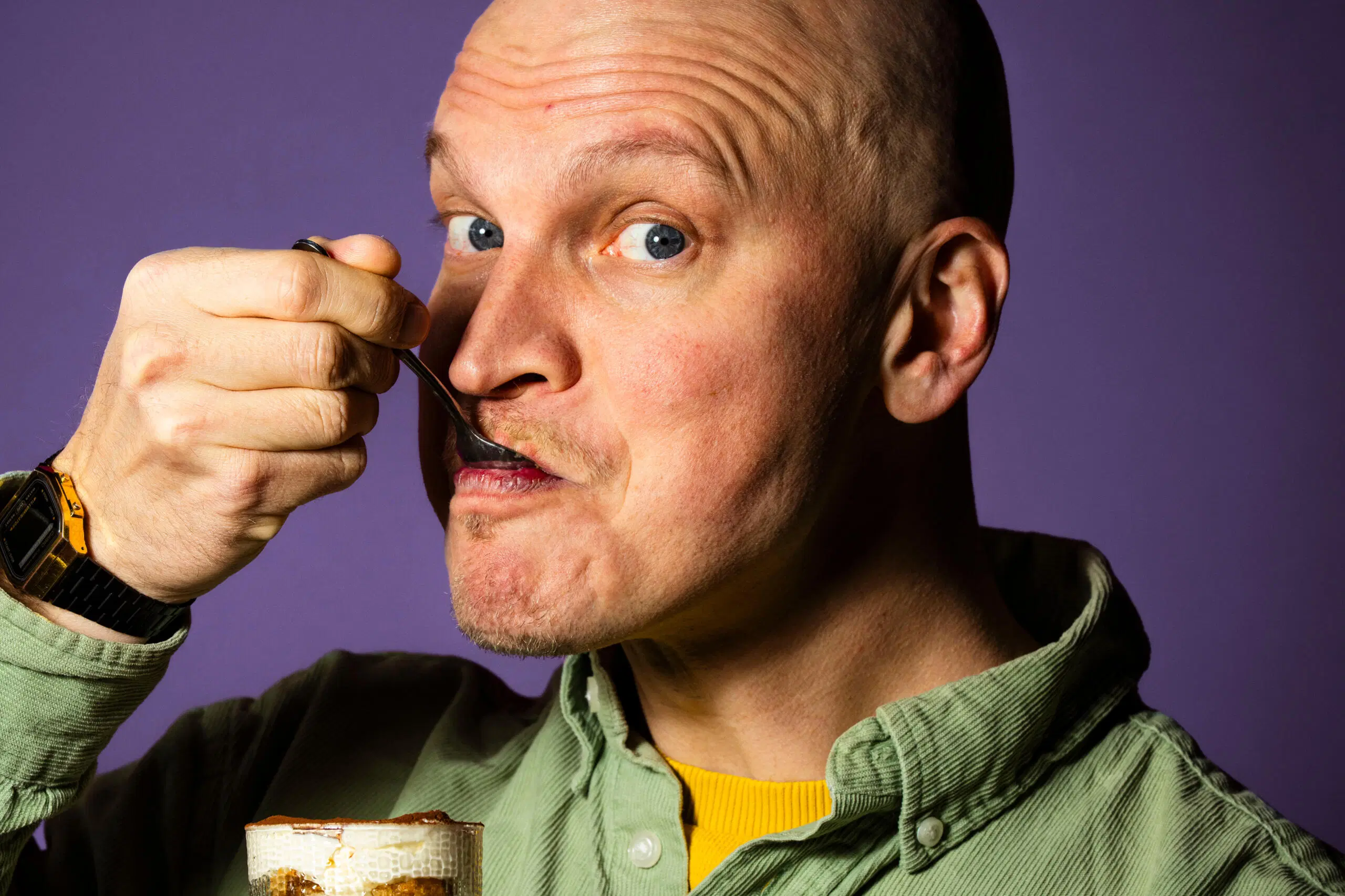 Mies syö tiramisua lasista