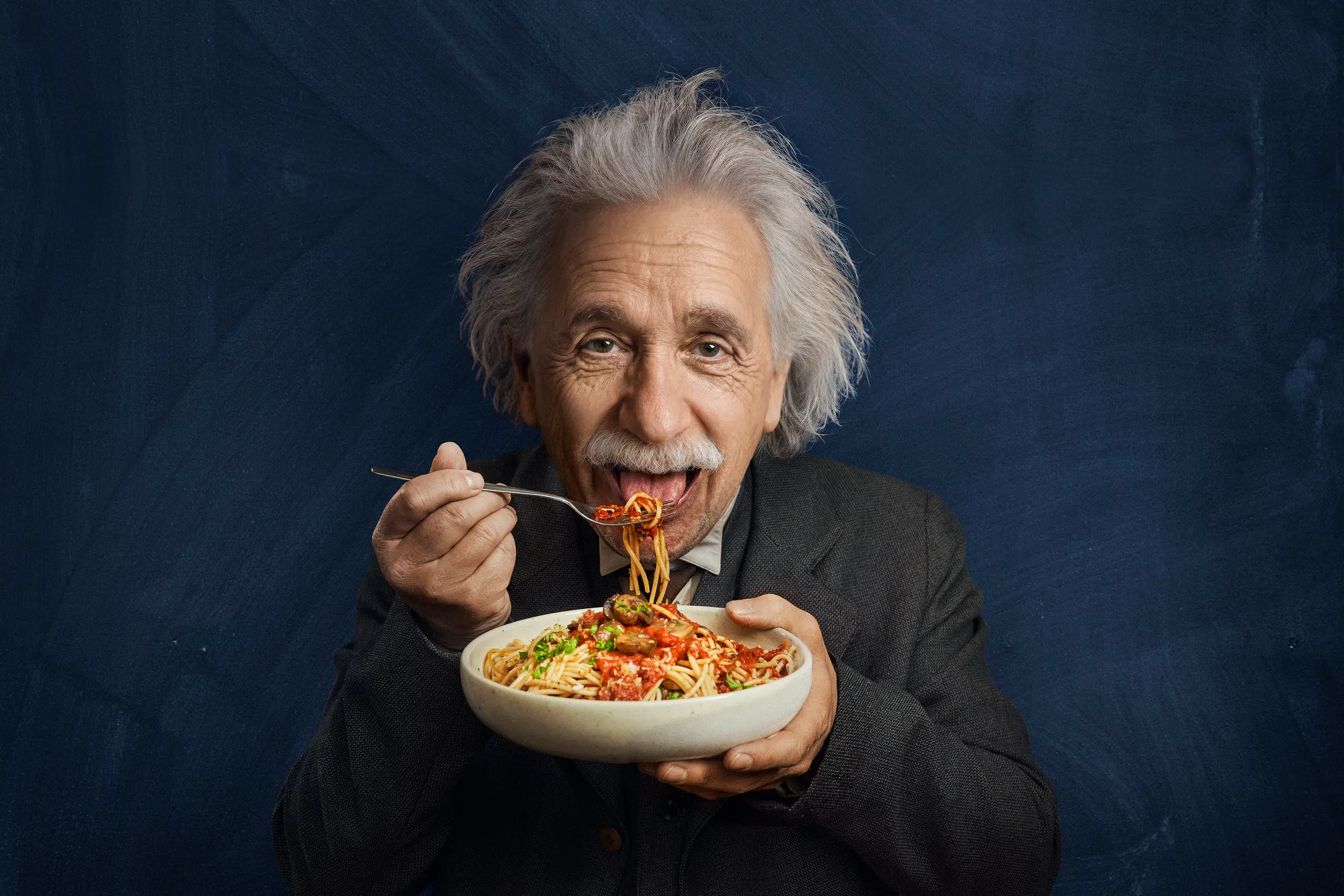 Einstein syö pastaa lautaselta. Kuva luotu tai muokattu tekoälyllä. Kuva luotu tai muokattu tekoälyllä.