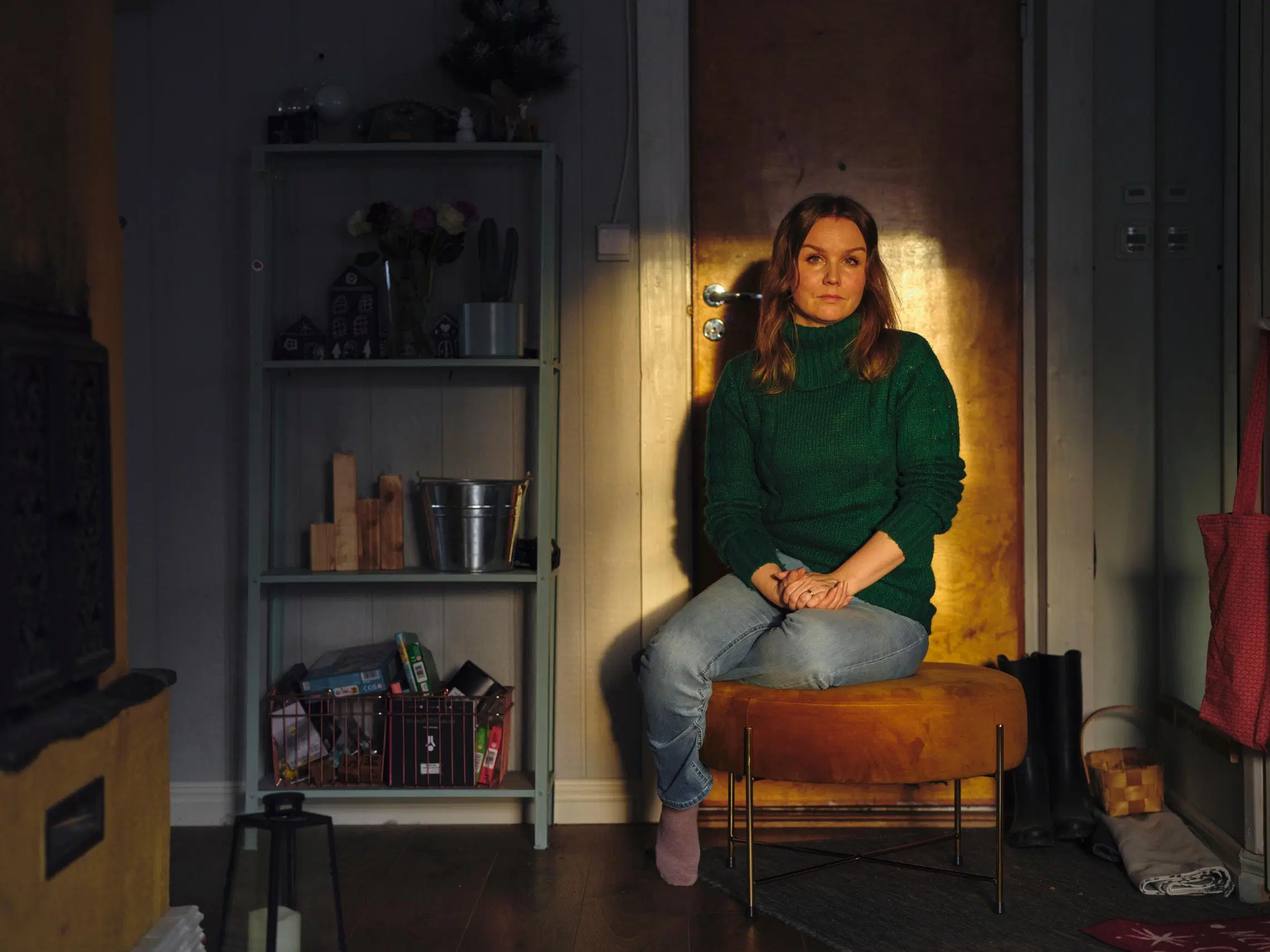 Natasa Höök istuu oven edessä auringosta tulevassa valoläikässä.