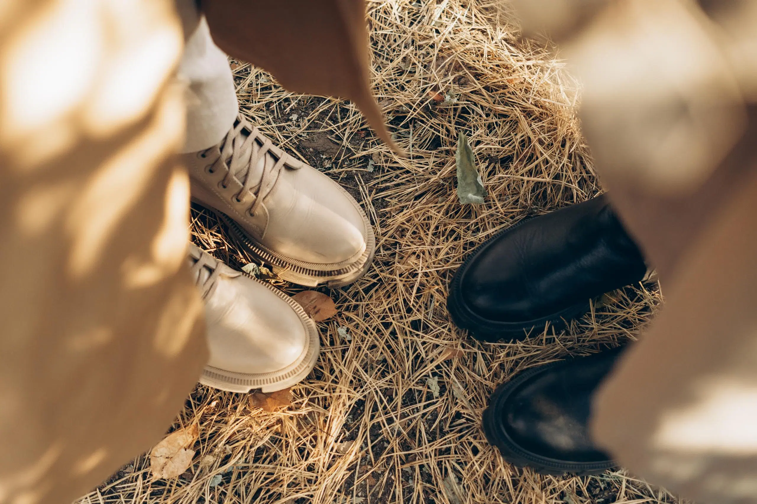 Kahden naisen jalat talvisaappaissa kuvattuna ylhäältä päin.