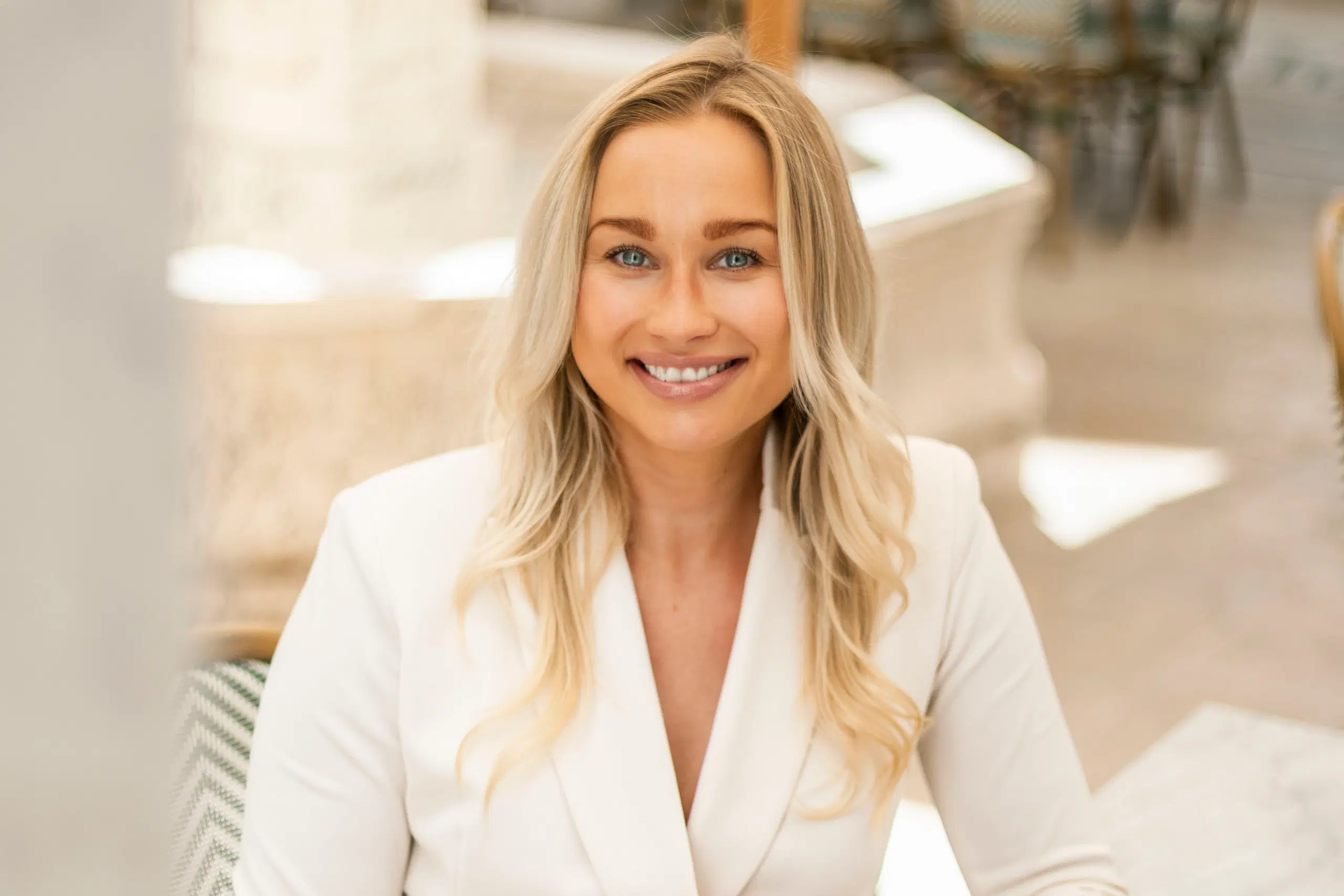 Nainen katsoo kameraan ja hymyilee