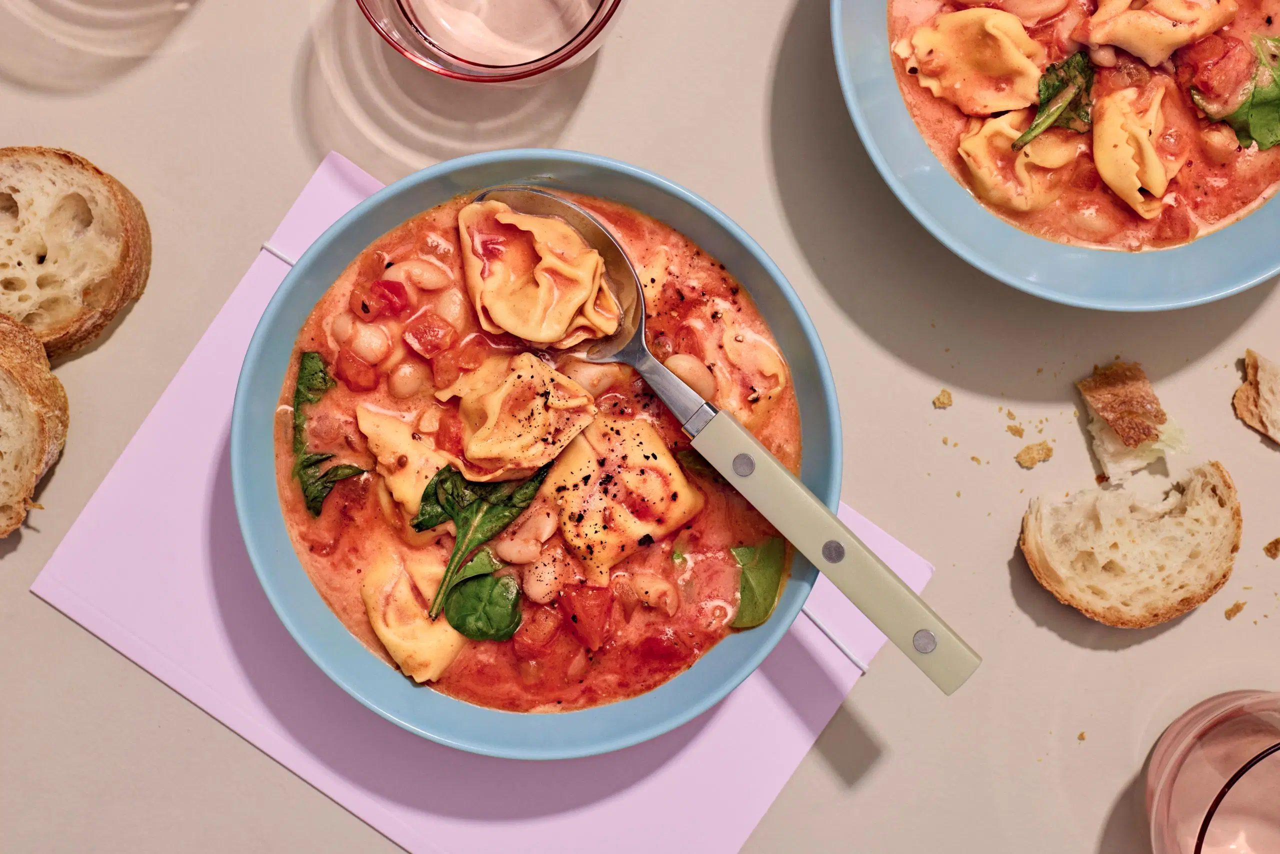 Kulho, jossa on nopeaa tortellonikeitto ja lusikka.