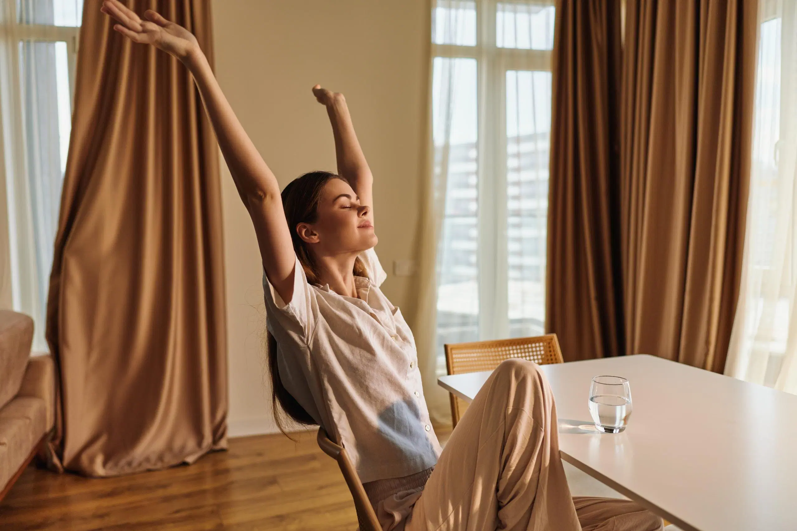 Rentoutunut nainen venyttelee pöydän ääressä