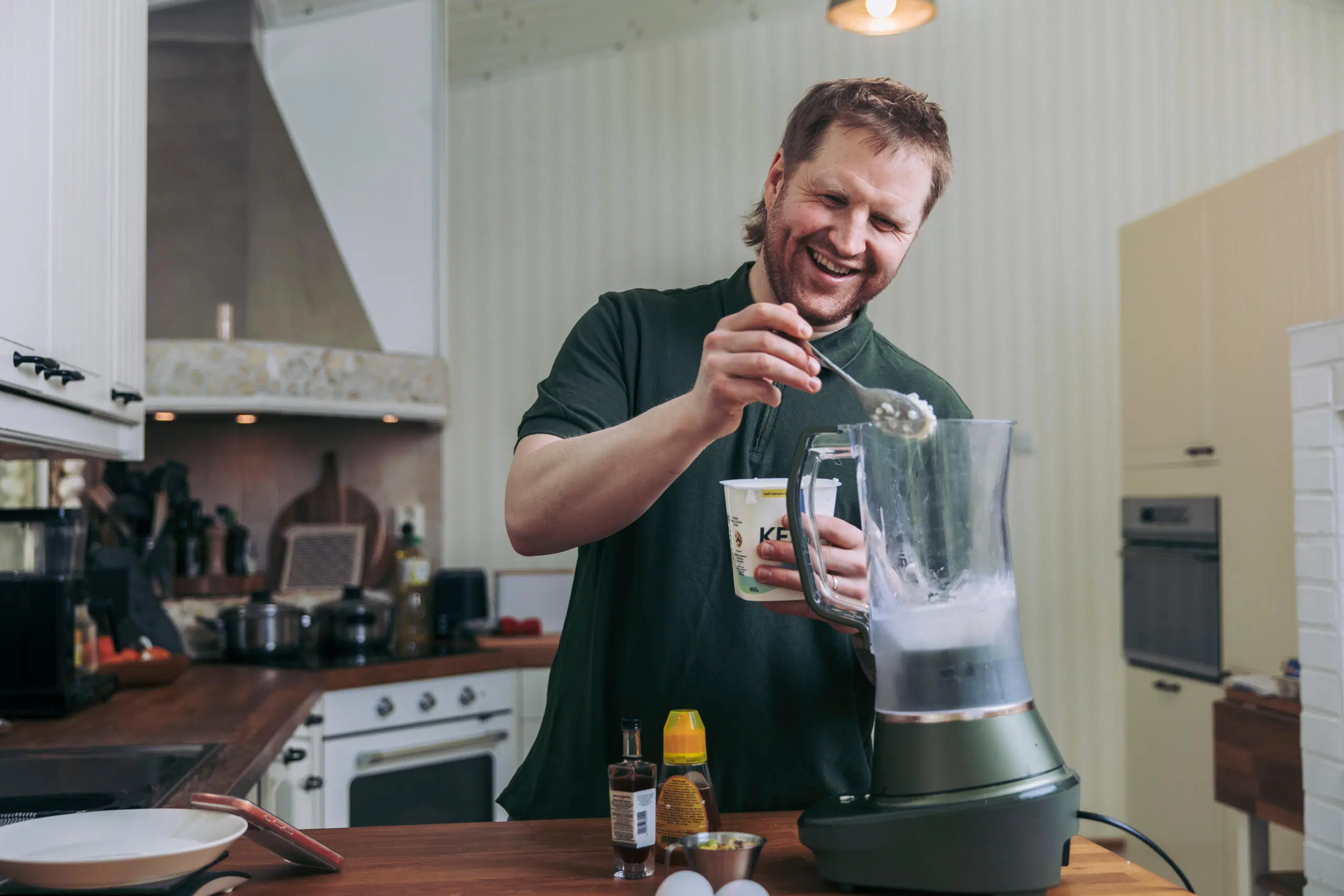 Tommi Manninen lusikoi raejuustoa tehosekoittimeen.