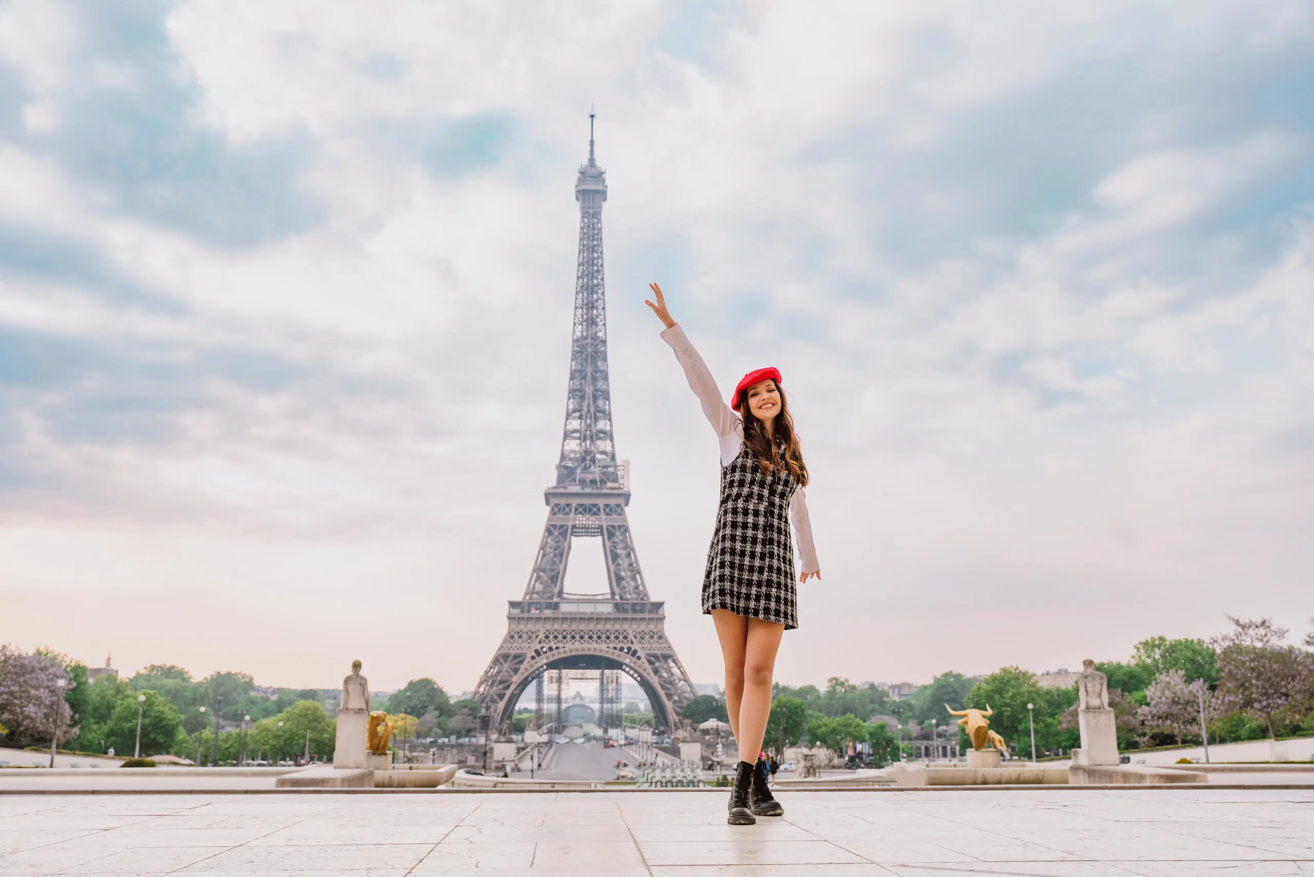 Tyylikkäästi pukeutunut nainen Eiffel-tornin vierellä