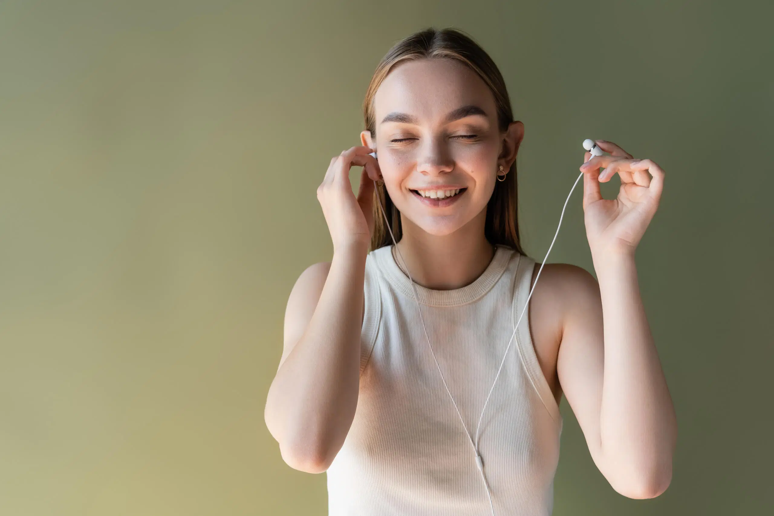 Nuori nainen kuuntelee musiikkia langallisista kuulokkeista