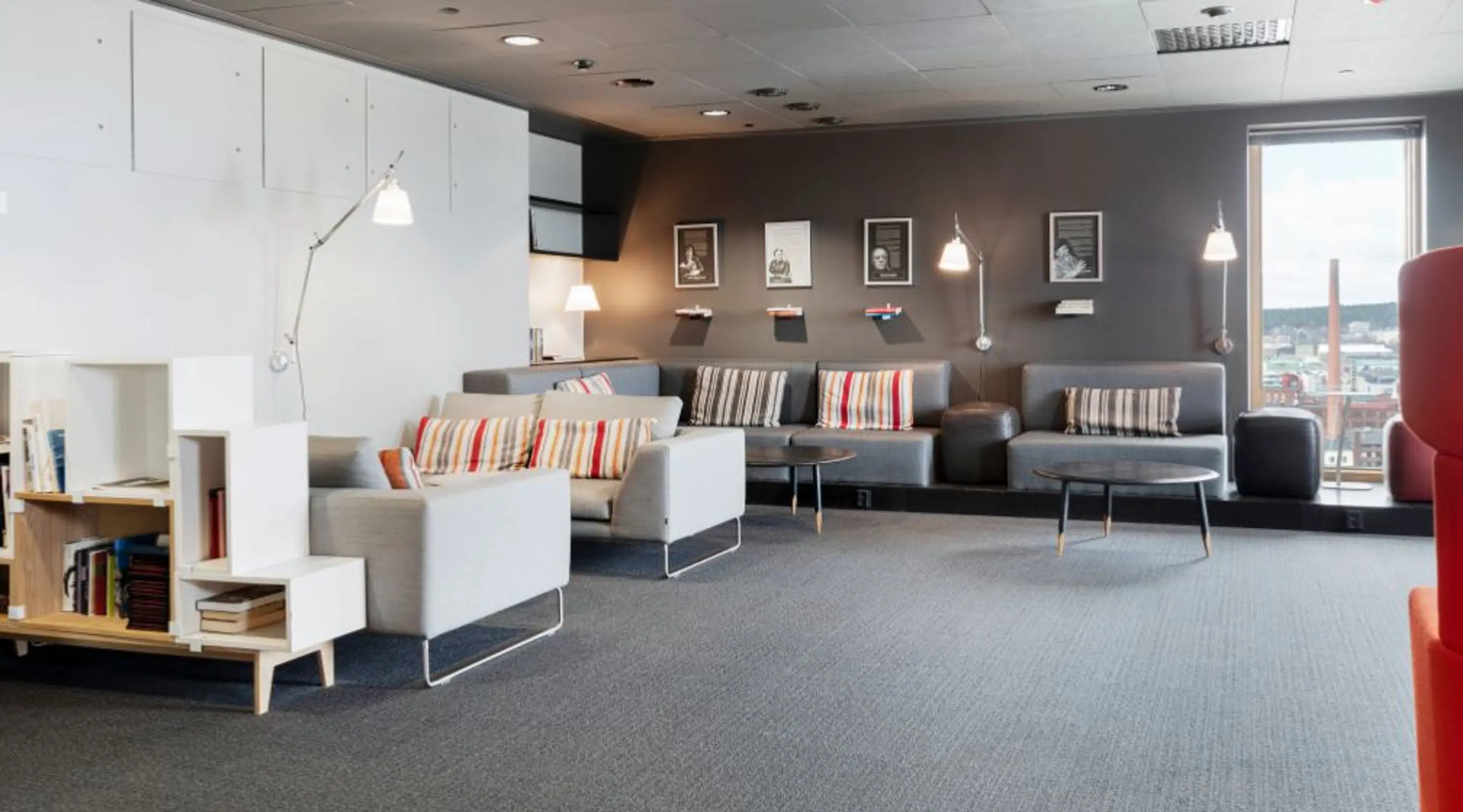 Spacious lounge area with low-pile carpet, grey sofas and good lighting. Step-free access.