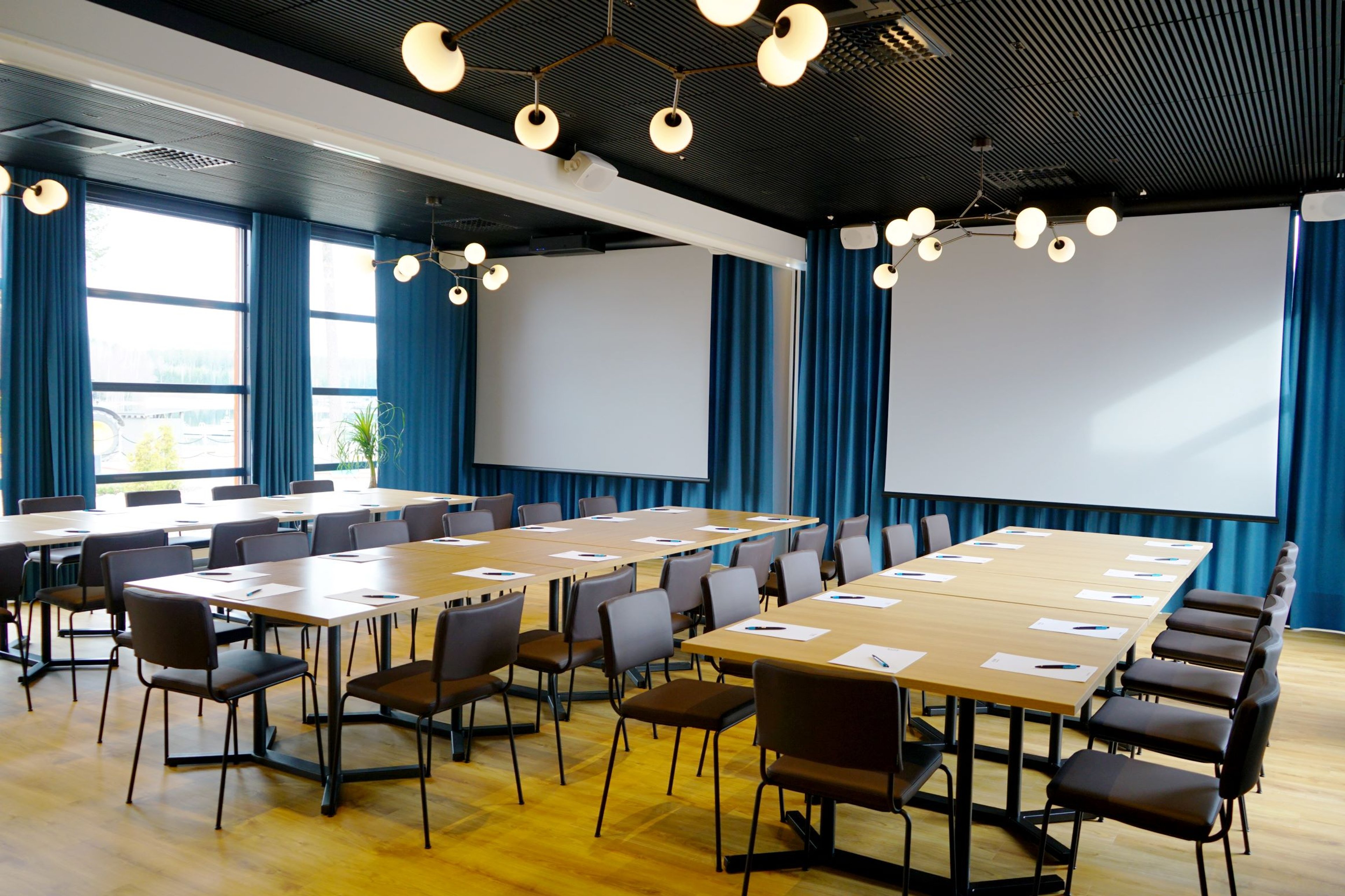 Moderni ja valoisa neuvotteluhuone isoilla ikkunoilla ja järvinäköalalla.