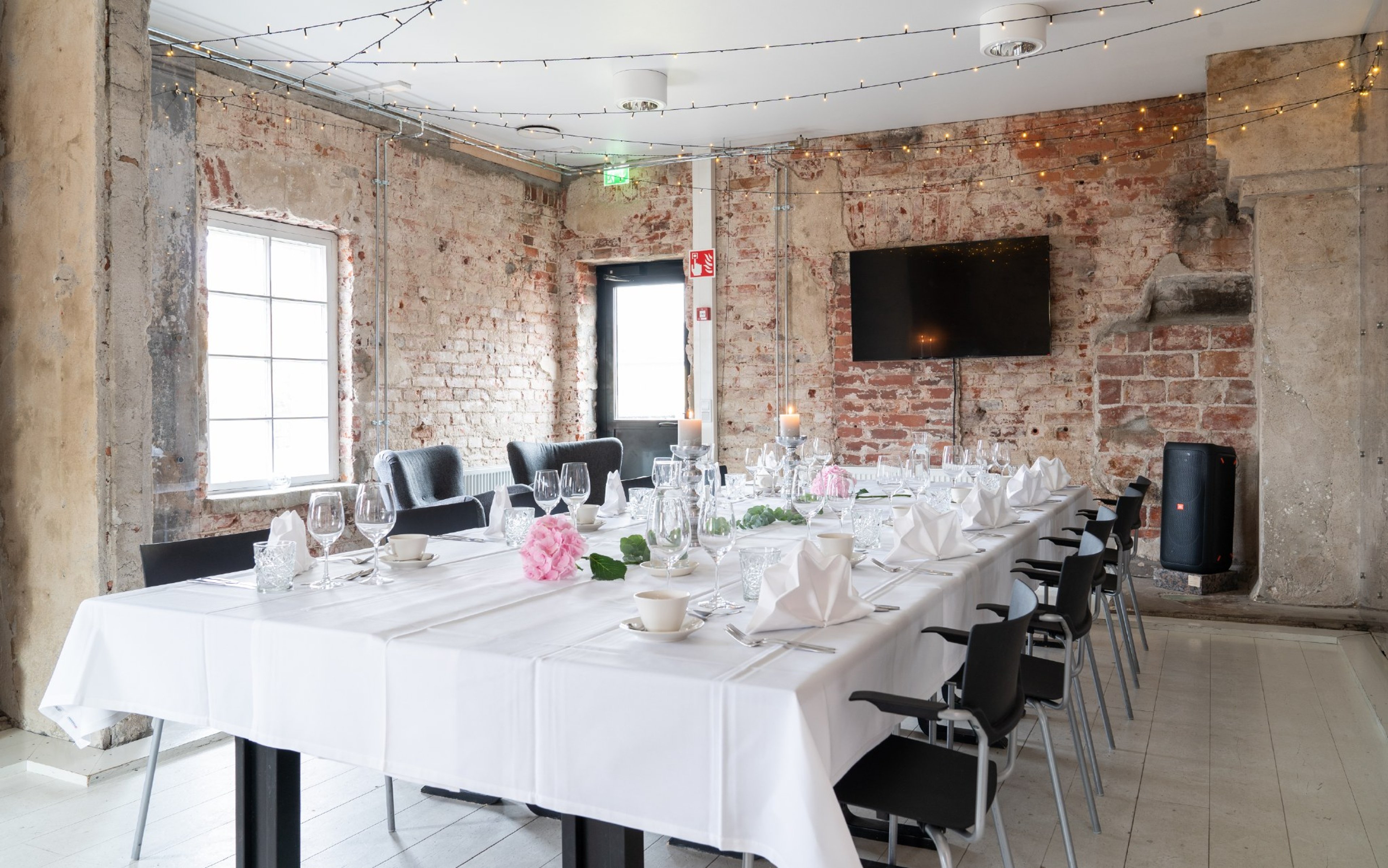 Valoisa tila, jossa on kokoustekniikka ja mahdollisuus muokata pöytiä kokouksiin ja juhliin sopiviksi.