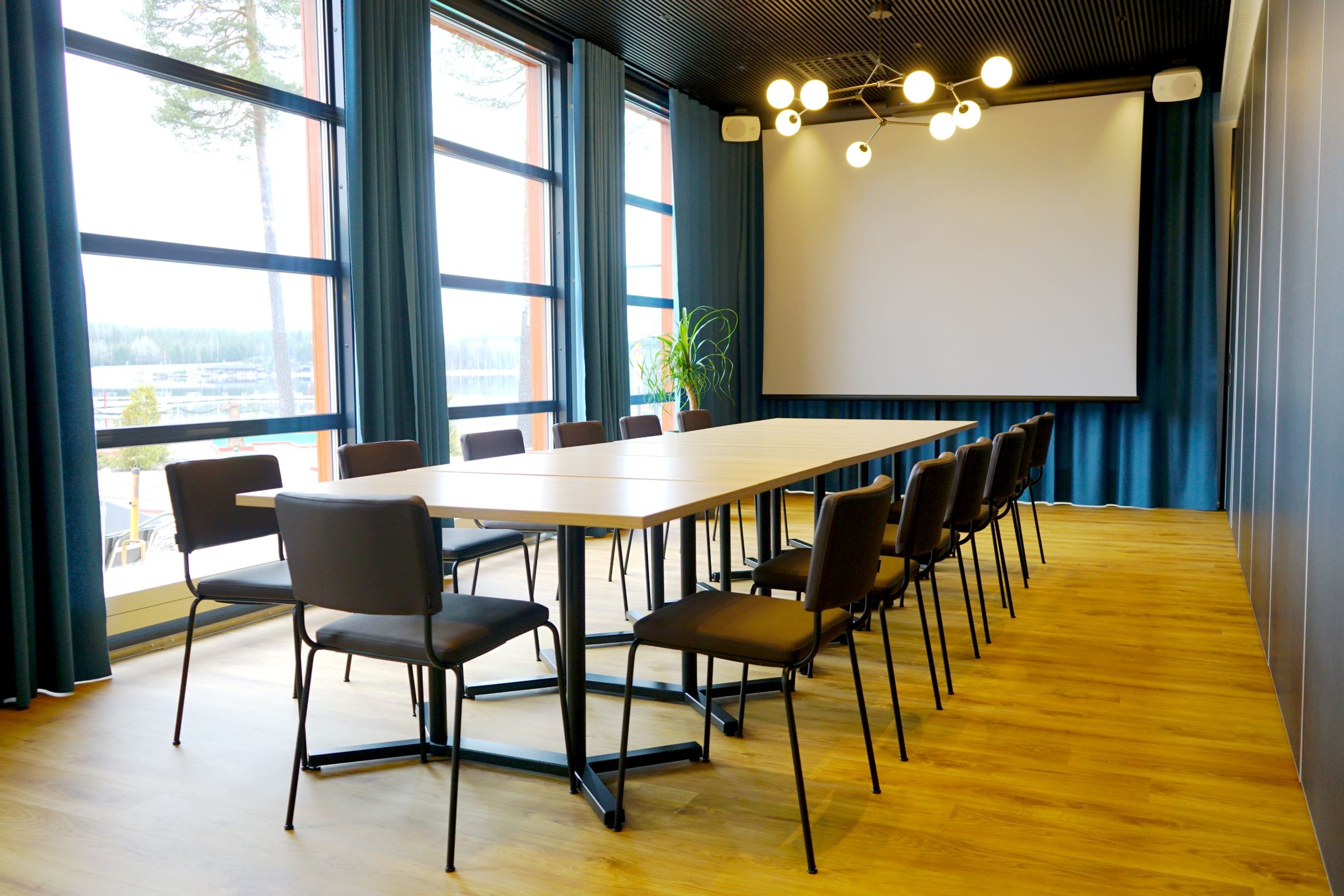 Moderni ja valoisa neuvotteluhuone isoilla ikkunoilla ja järvinäköalalla.