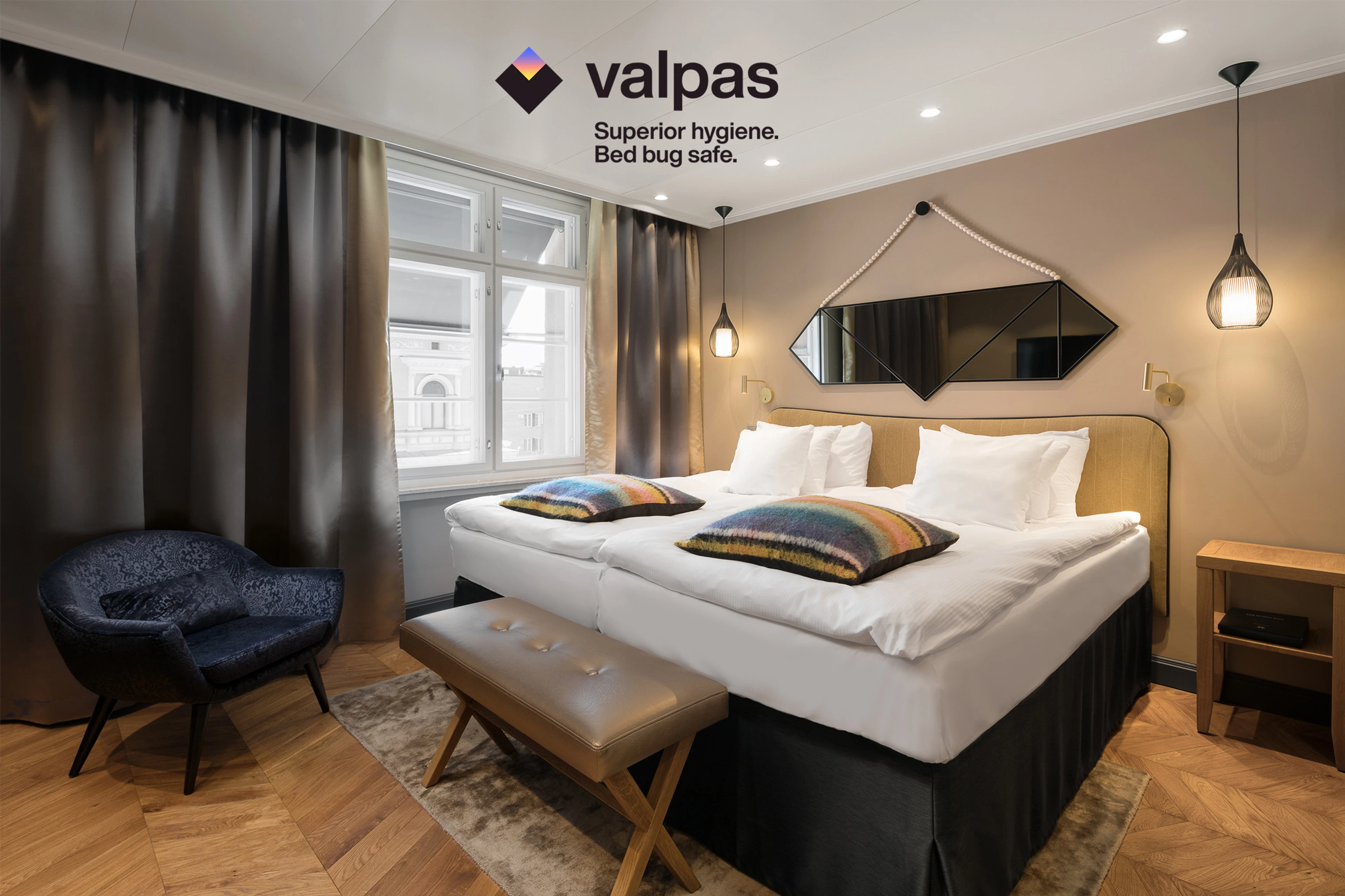 Kuvassa Solo Sokos Hotel Turun Seurahuoneen hotellihuone, jossa parivuode, nojatuoli ja sängynpäätyrahi.