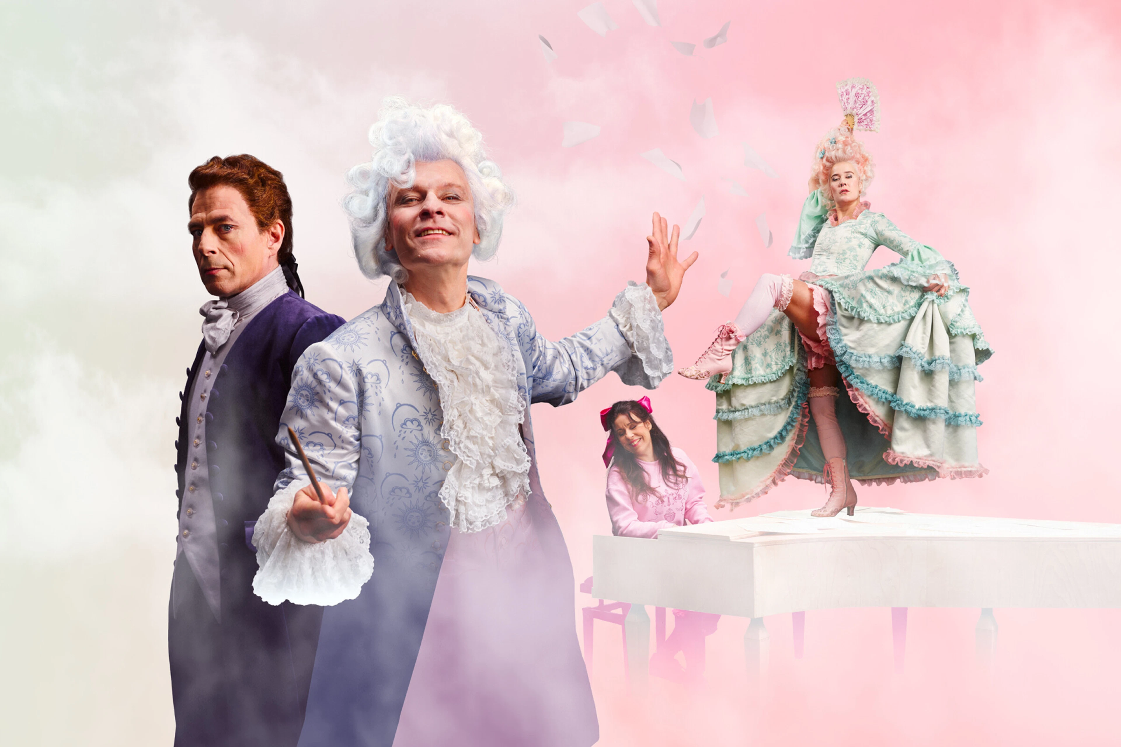 Four performers in rococo-style costumes against a soft pink and cream backdrop.
