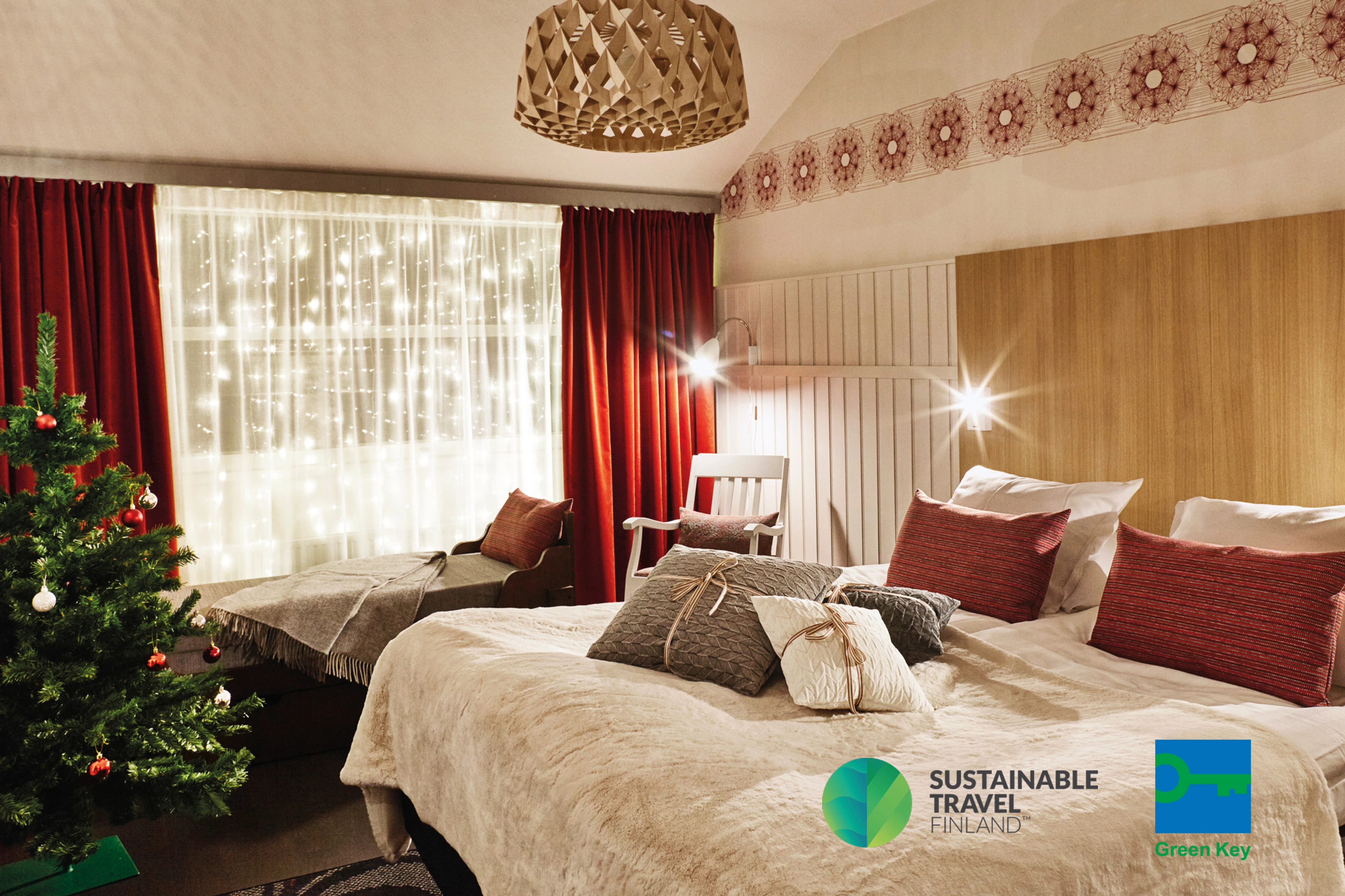 Green Key -sertifikaatti ja Sustainable Travel Finland -merkki. Kuvassa Rovaniemen Original Sokos Hotel Vaakunan joulu-teemahuone.