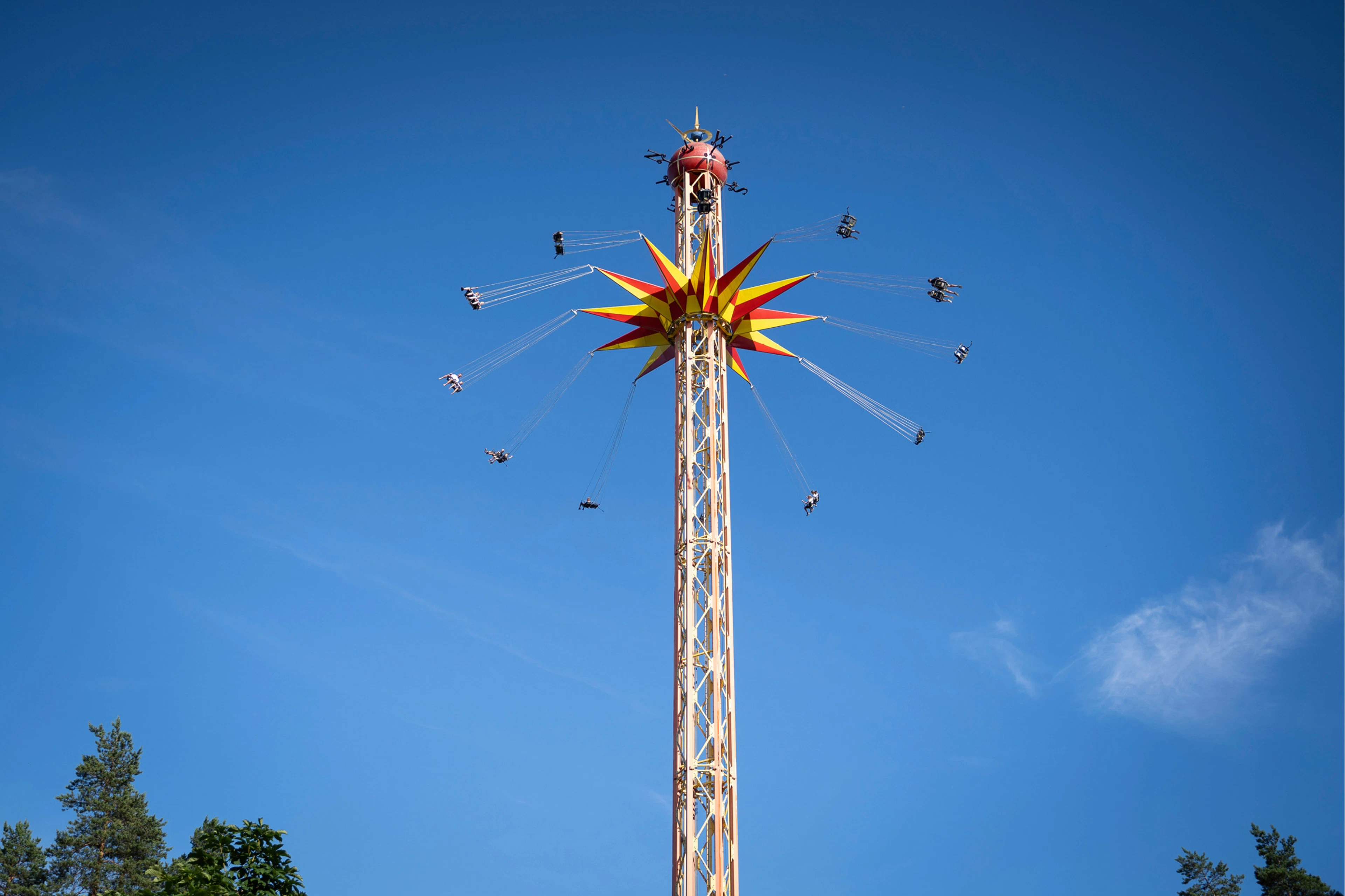 Tykkimäen huvipuiston korkea Star Flyer -laite pyörittää huvipuistokävijöitä sinistä taivasta vasten.