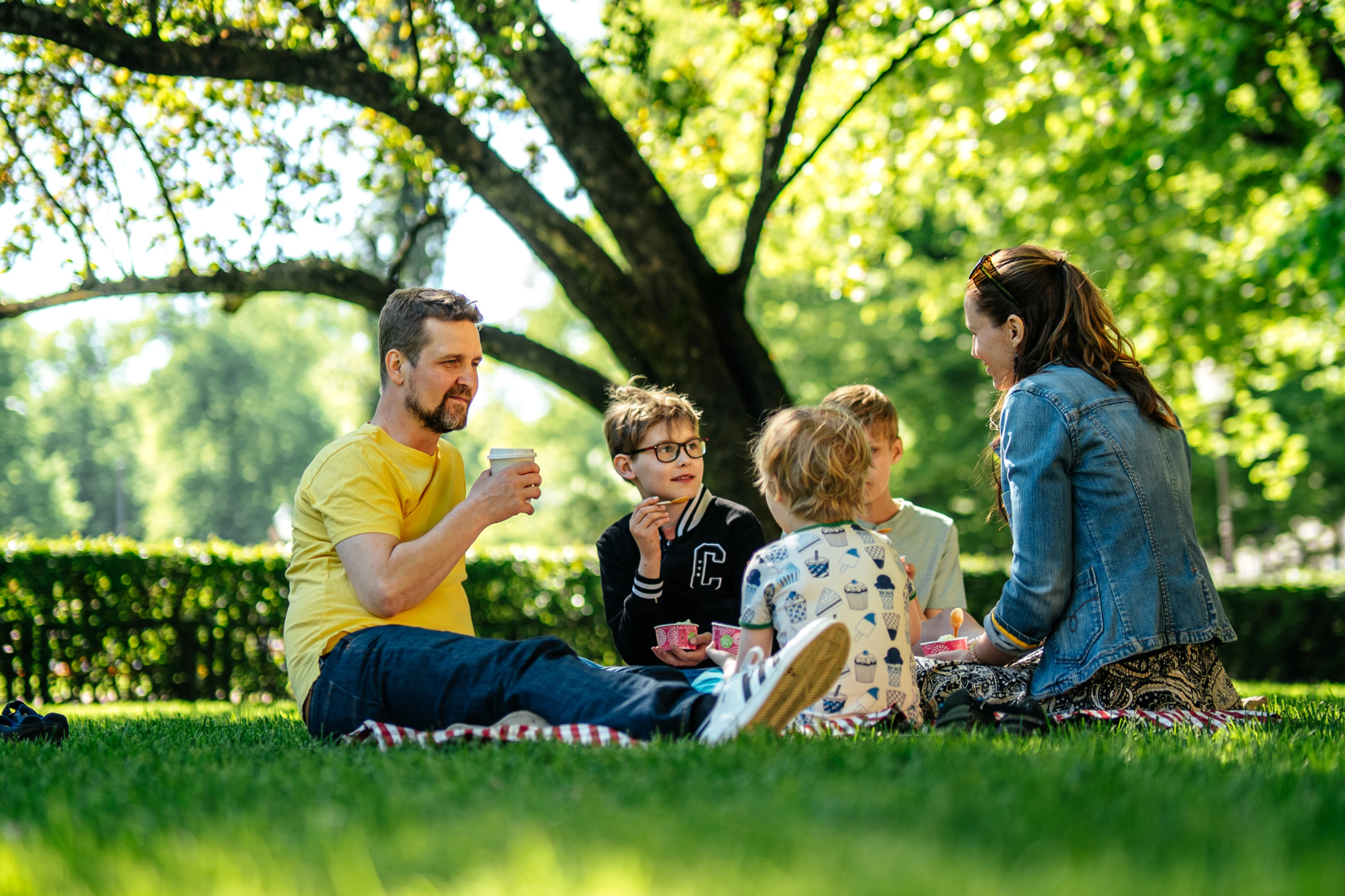 Familj på picknick i parken.