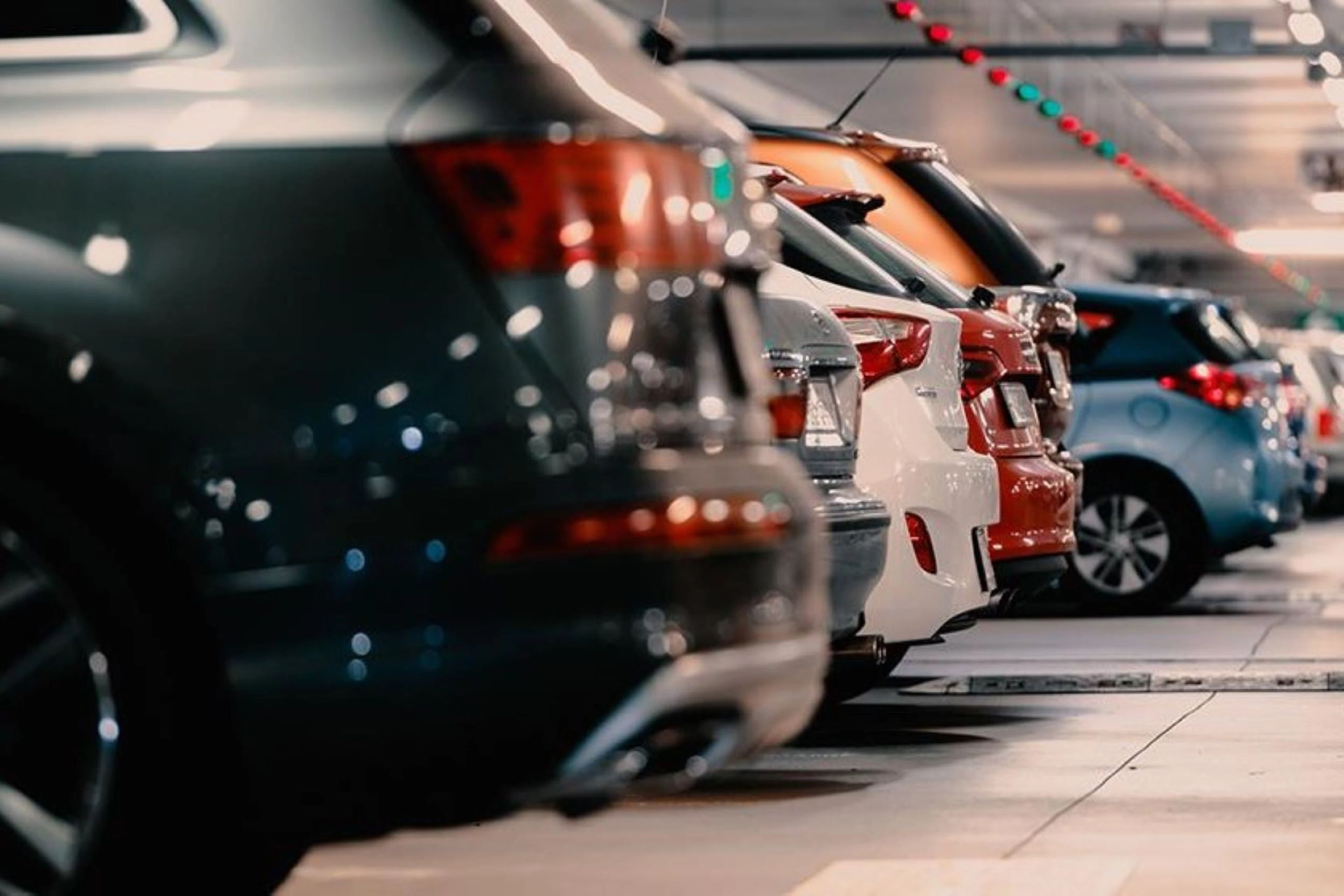 Cars parked in a row in a parking garage.