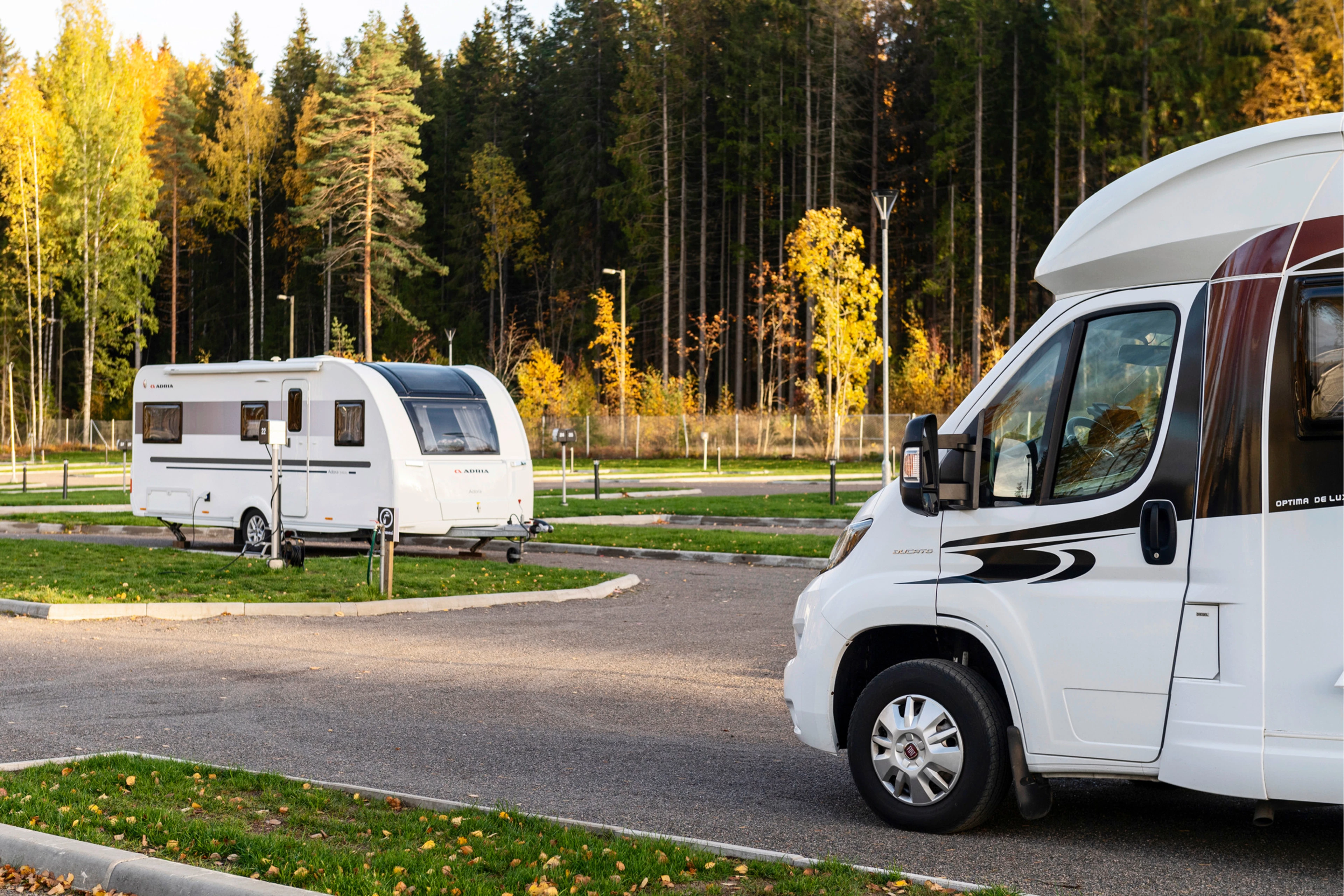 Asuntoauto ja -vaunu ovat pysäköityinä resortin camping-alueelle.