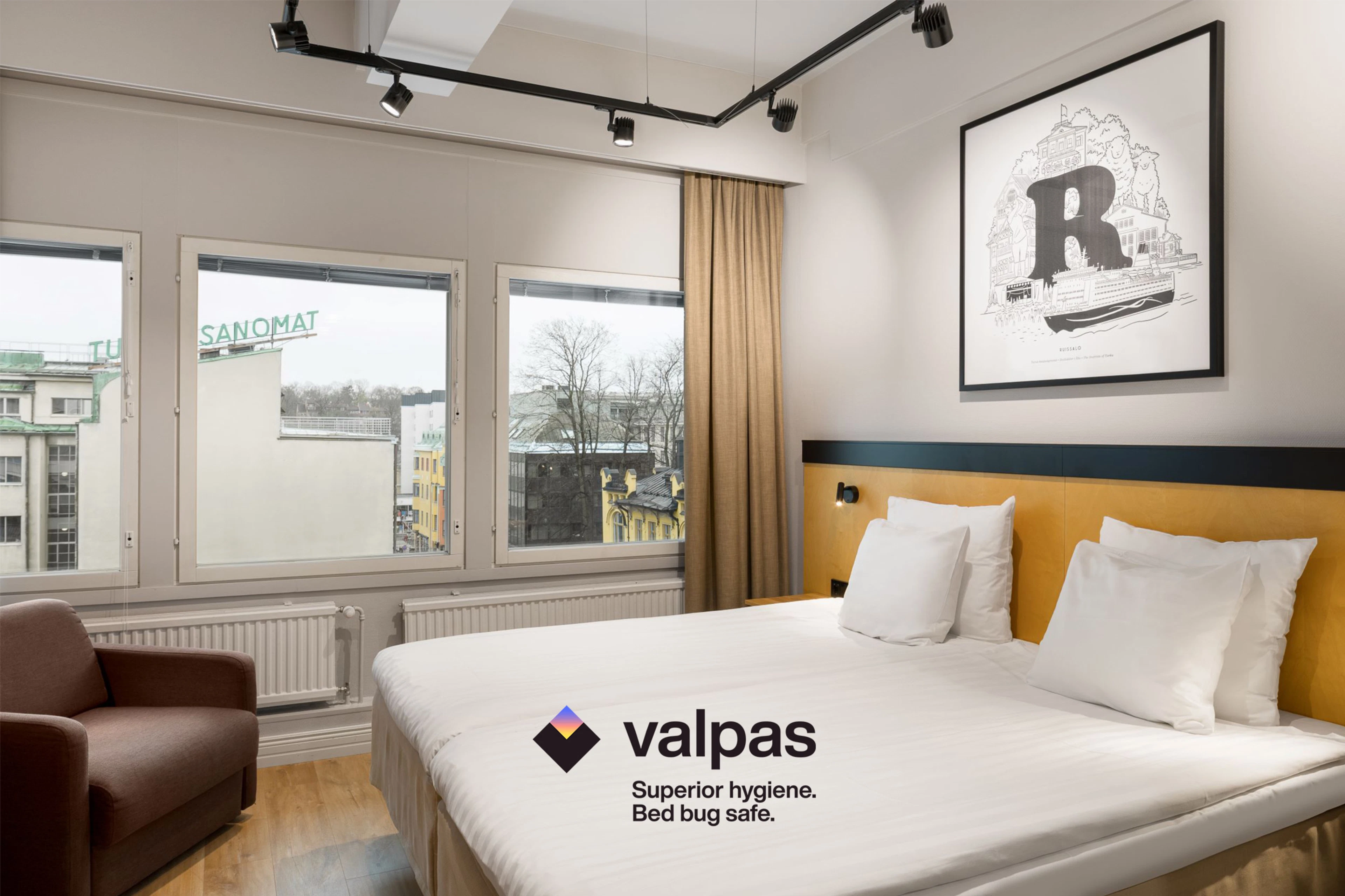 Kuvassa Original Sokos Hotel Wiklundin hotellihuone, jossa näkyy parivuode ja nojatuoli.