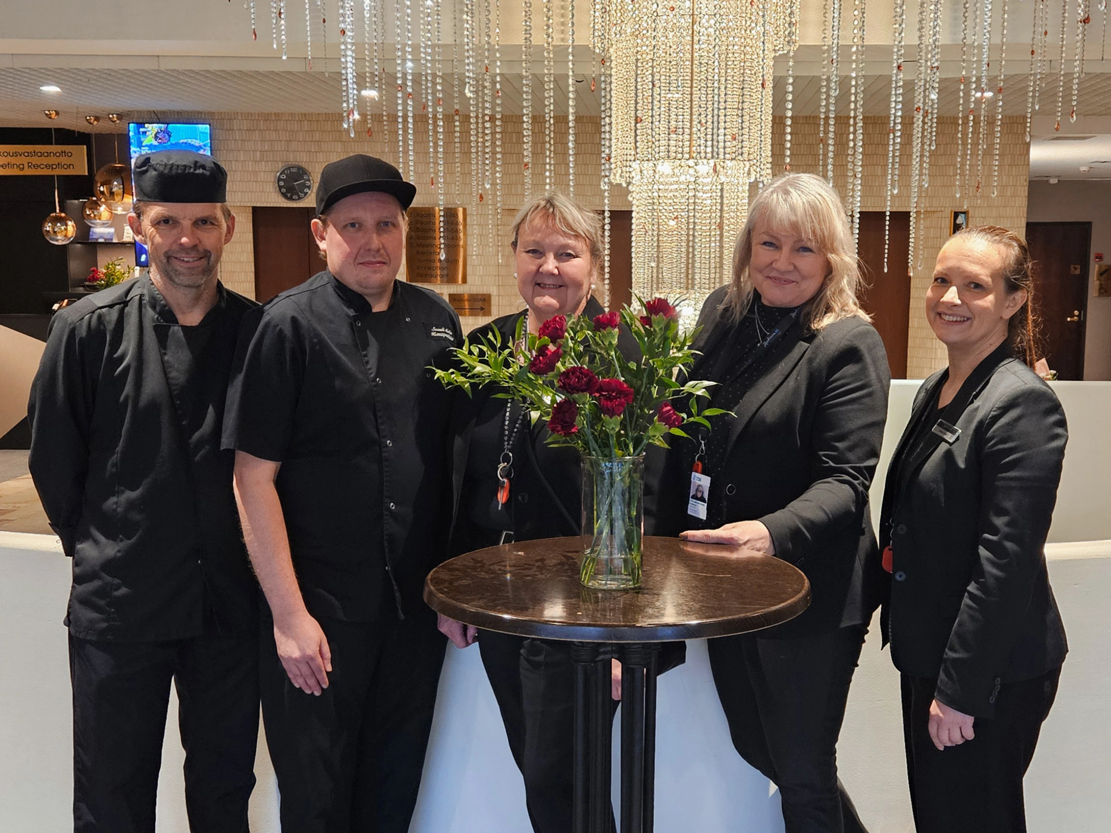 Kuvassa viisi esihenkilöä iloitsemassa hotellin aulatiloissa World Luxury Awards -palkintoa