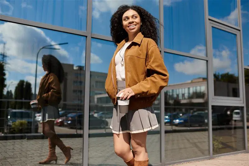 Nainen kävelee auringossa mokkanahkatakki päällään