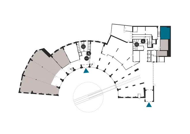 Floor plan showing a curved building layout with multiple rooms and accessible toilet facilities marked.